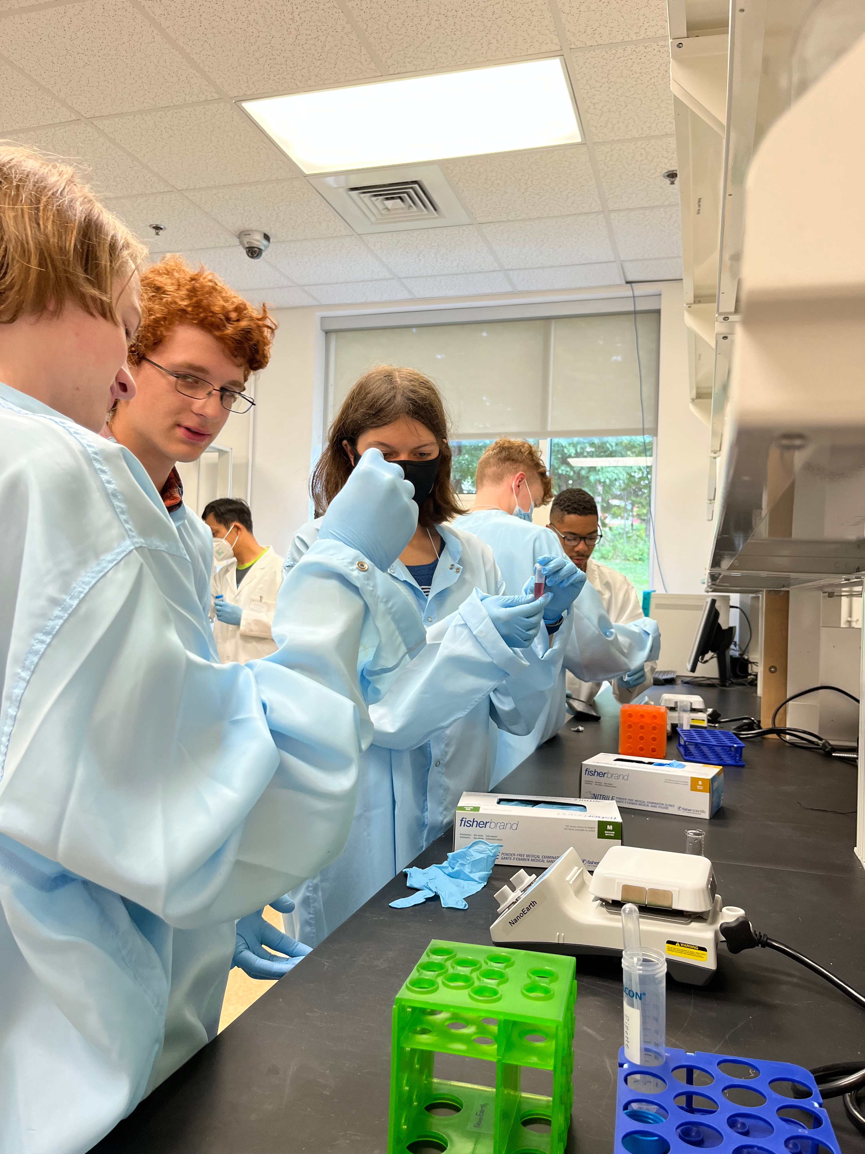 Students in lab coats synthesize gold nanoparticles