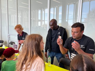 Bipin Lade explains ferrofluids to a festival attendee as other visitors experience other NanoEarth demos in the background