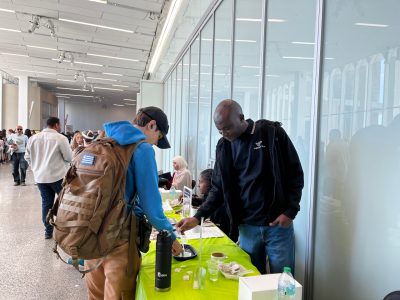 A festival visitor learns about hydrophobic nano-pants with Emanuel Irumhe