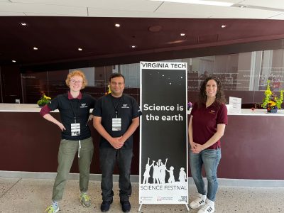 Charis Horn, Bipin Lade, and Sylvianne Velasquez pose with the festival sign