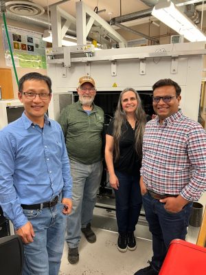 Weinan Leng, David Mogk, Sara Zacher, and Bipin Lade pose in front of the Scanning Auger Electron Microprobe and SEM with cryo and cathodoluminescence (CL) capabilities, MONT